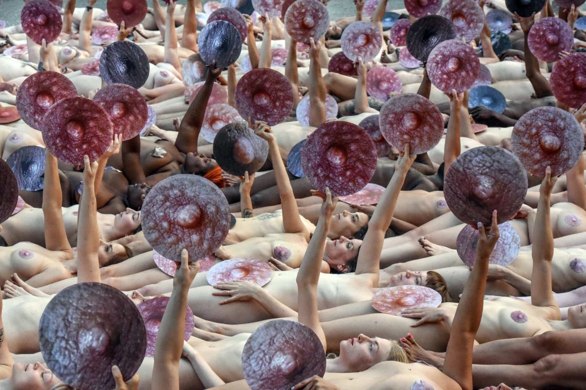 People pose nude holding cut outs of nipples during a photo shoot by artist Spencer Tunick on June 2, 2019 in New York 