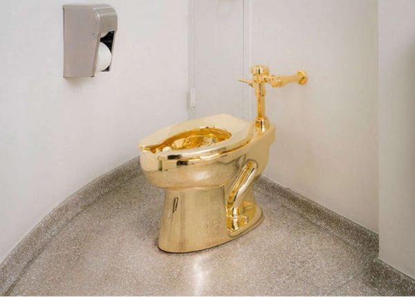 the sculpture is a toilet bowl of 103 kg of 18 karat gold, fully functional. The work is surely a perfect example of satirical relational art. The toilet was stolen from Blenheim Palace in Oxford, where it was exhibited, but the work is part of the Solomon R. Guggenheim Museum collection in New York. 